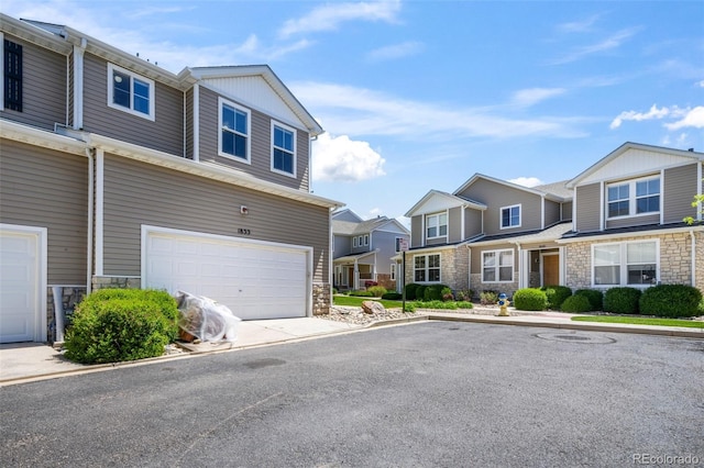 view of front of property with stone siding, a residential view, and a garage