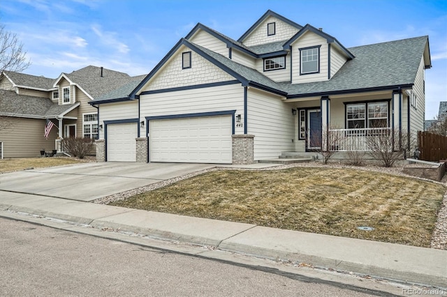 view of front of home featuring a garage, covered porch, and a front yard