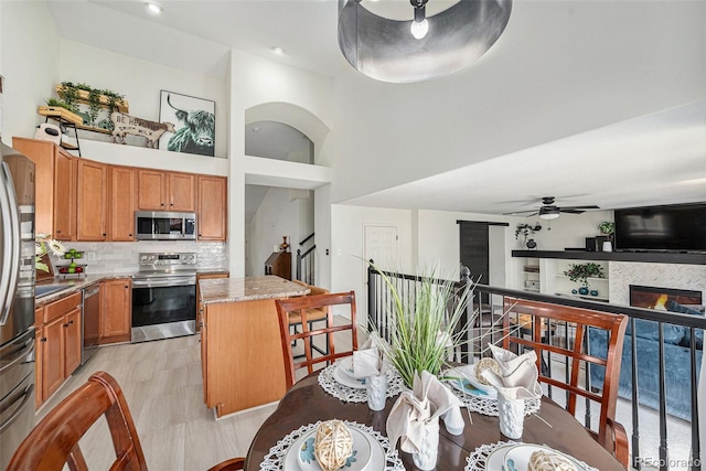 15776 E 107th Way, Commerce City, CO 80022 - kitchen featuring stainless steel appliances, a center island, ceiling fan, a high ceiling, and backsplash
