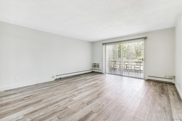 unfurnished room with a textured ceiling, baseboard heating, light wood-type flooring, and a wall mounted air conditioner