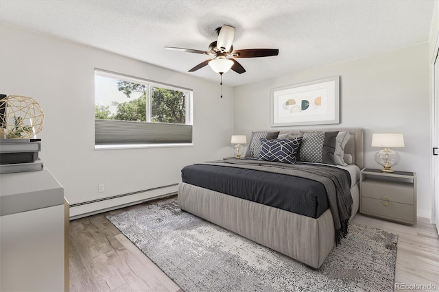 bedroom featuring light hardwood / wood-style floors, a textured ceiling, a baseboard radiator, and ceiling fan