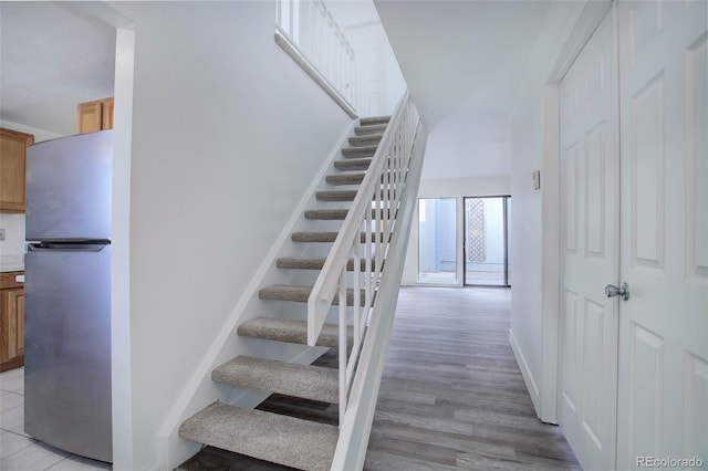 stairs with wood finished floors and baseboards