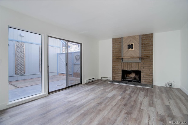 unfurnished living room with a fireplace, visible vents, light wood-style flooring, baseboard heating, and baseboards