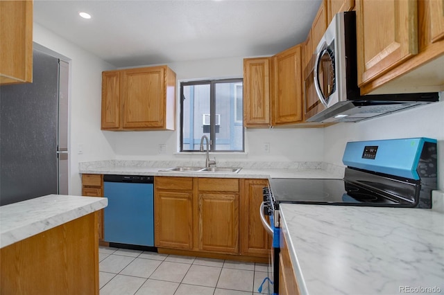 kitchen with light tile patterned floors, brown cabinetry, appliances with stainless steel finishes, light countertops, and a sink