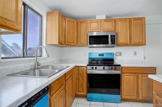 kitchen with light tile patterned floors, brown cabinets, stainless steel appliances, light countertops, and a sink