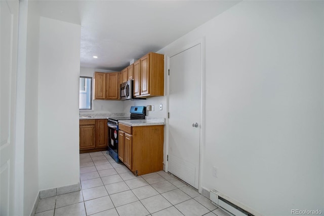 kitchen with brown cabinetry, appliances with stainless steel finishes, baseboard heating, light countertops, and light tile patterned flooring