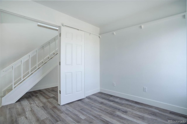 unfurnished bedroom with a closet, baseboards, and wood finished floors