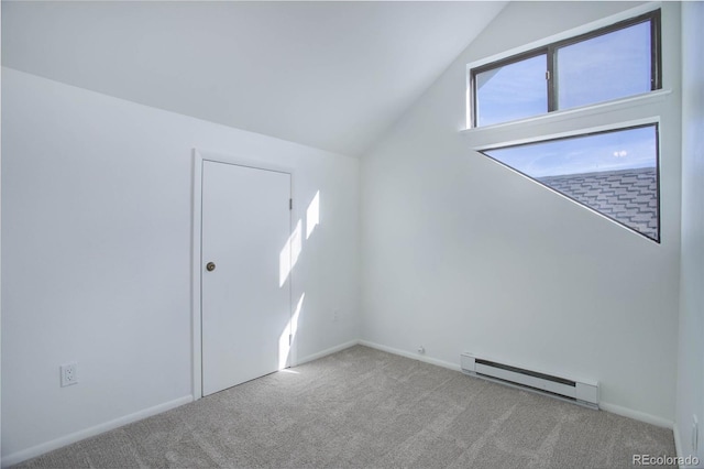 empty room with a baseboard radiator, light colored carpet, and vaulted ceiling