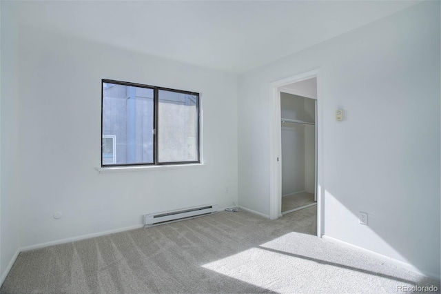 unfurnished bedroom featuring light carpet, baseboard heating, a closet, and baseboards