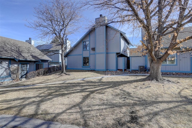 view of home's exterior with a chimney and central AC unit