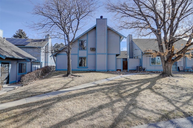 exterior space with central AC unit and a chimney