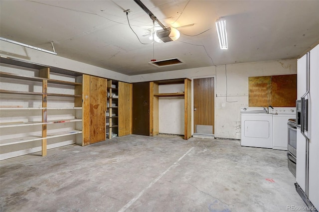 garage with separate washer and dryer and a garage door opener