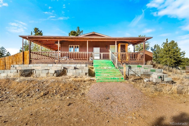 view of front of property featuring a porch and fence