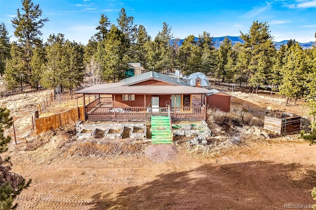 view of front of property with a vegetable garden, fence, and a mountain view