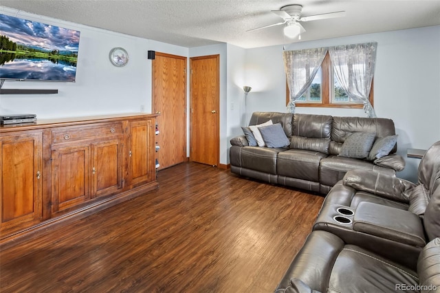 living room with ceiling fan, a textured ceiling, and dark wood-style flooring