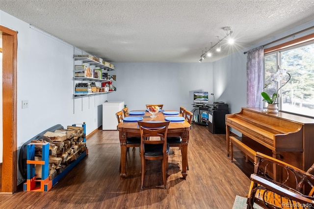 dining room with a textured ceiling and wood finished floors