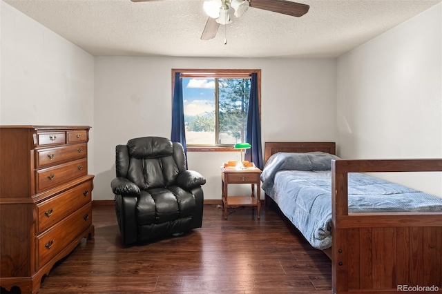 bedroom featuring a ceiling fan, dark wood finished floors, and a textured ceiling