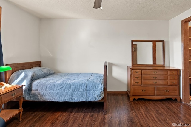 bedroom with a textured ceiling, ceiling fan, dark wood finished floors, and baseboards