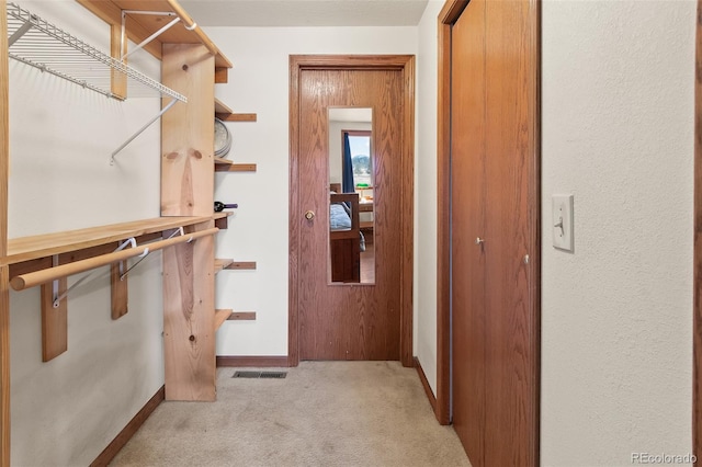 spacious closet with light carpet and visible vents