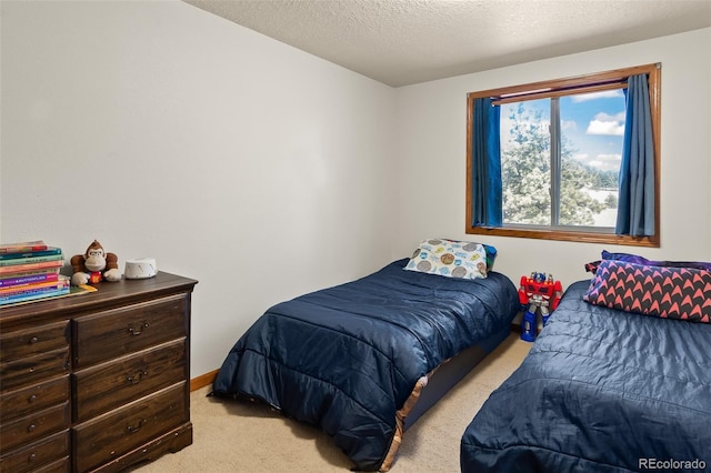 bedroom with a textured ceiling, baseboards, and light colored carpet