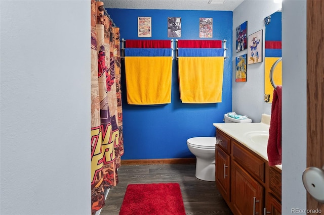 bathroom featuring baseboards, vanity, toilet, and wood finished floors