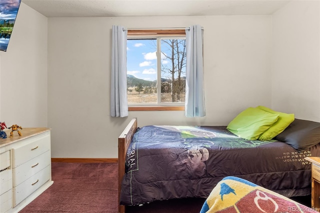 bedroom featuring baseboards and dark colored carpet