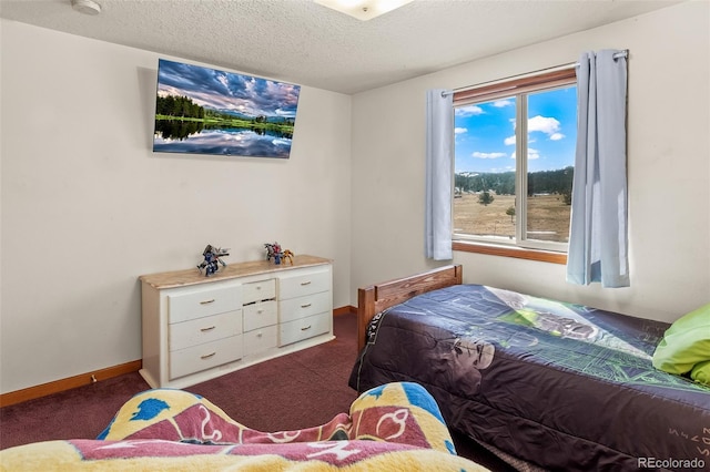 bedroom with a textured ceiling, carpet floors, and baseboards