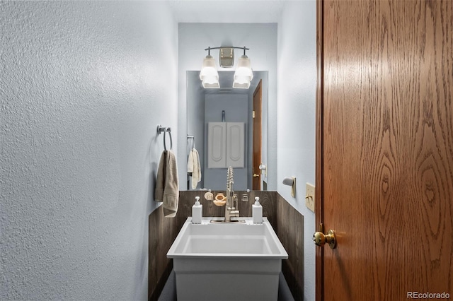 bathroom with vanity and a textured wall