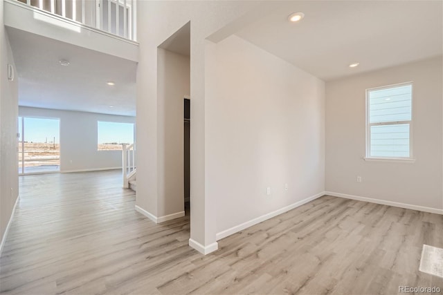empty room featuring wood finished floors, plenty of natural light, baseboards, and recessed lighting