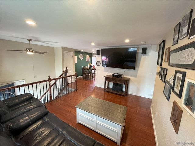 living room featuring ceiling fan and dark hardwood / wood-style floors