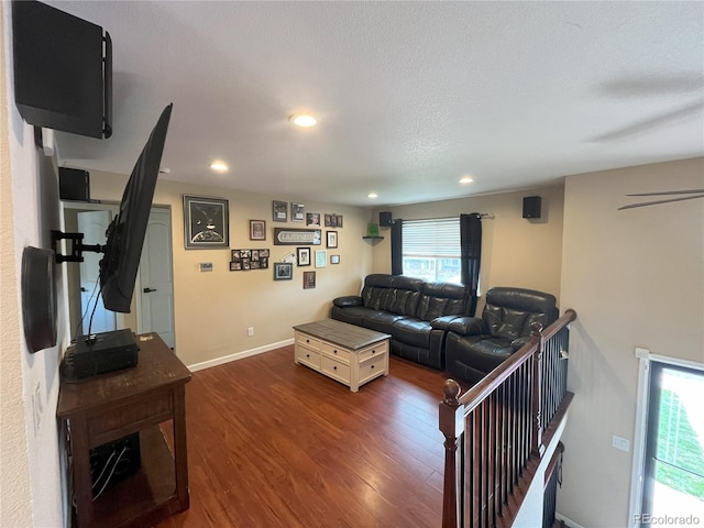 living room featuring a wealth of natural light, dark wood-type flooring, and a textured ceiling