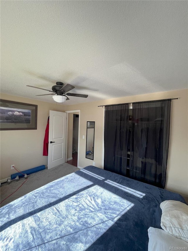 bedroom with carpet flooring, a textured ceiling, and ceiling fan