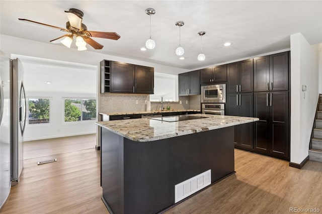 108 Olympus Cir, Lone Tree, CO 80124 - kitchen featuring appliances with stainless steel finishes, light wood-style floors, recessed lighting, tasteful backsplash, and light stone counters