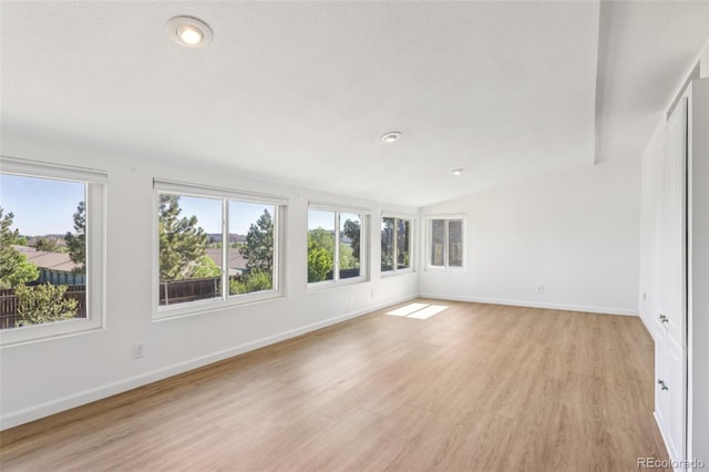 108 Olympus Cir, Lone Tree, CO 80124 - empty room featuring plenty of natural light, light wood-type flooring, lofted ceiling, and recessed lighting
