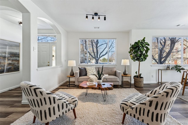 living room with rail lighting and dark wood-type flooring