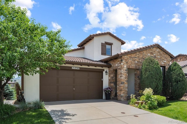 15290 W Baker Ave, Lakewood, CO 80228 - mediterranean / spanish home featuring concrete driveway, a garage, a tiled roof, stone siding, and stucco siding