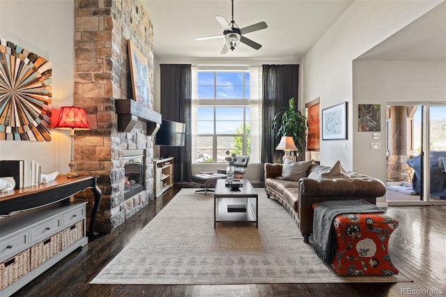 15290 W Baker Ave, Lakewood, CO 80228 - living area with healthy amount of natural light, a fireplace, a ceiling fan, and wood finished floors