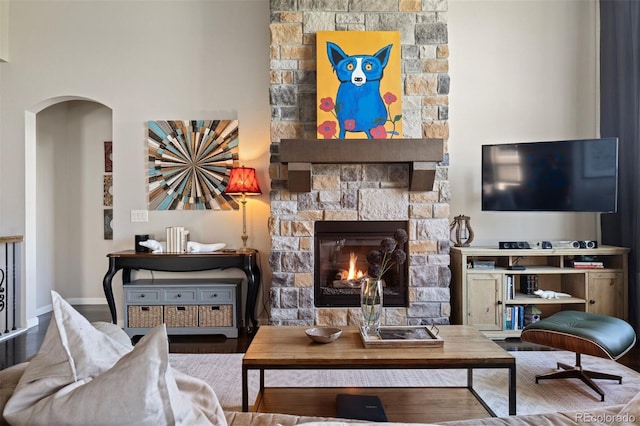 15290 W Baker Ave, Lakewood, CO 80228 - living area featuring arched walkways, a fireplace, and wood finished floors