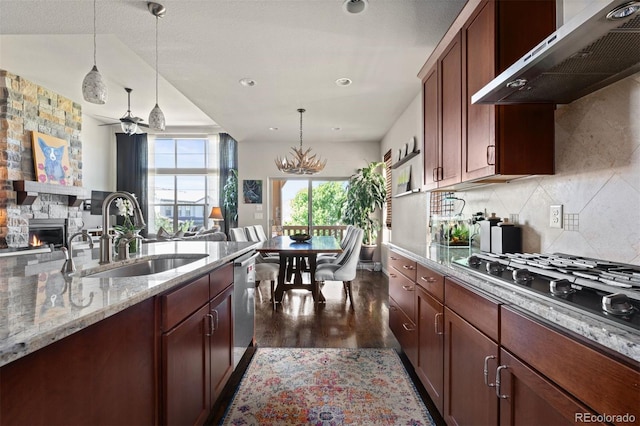 15290 W Baker Ave, Lakewood, CO 80228 - kitchen featuring extractor fan, stainless steel appliances, decorative light fixtures, open floor plan, and a stone fireplace