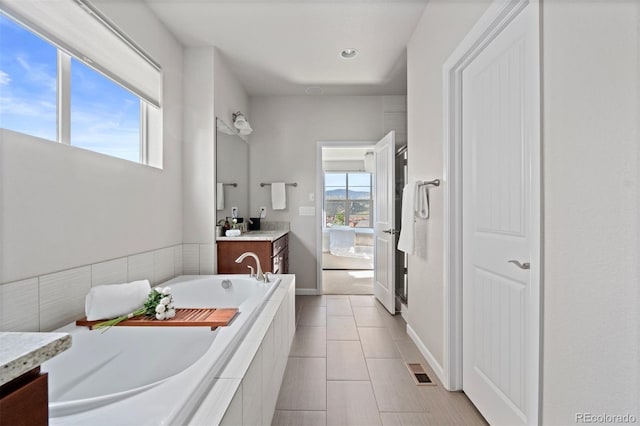 15290 W Baker Ave, Lakewood, CO 80228 - full bath featuring vanity, a bath, tile patterned flooring, and recessed lighting