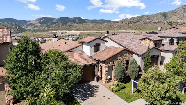 15290 W Baker Ave, Lakewood, CO 80228 - view of front of house featuring a tiled roof, stone siding, concrete driveway, and stucco siding