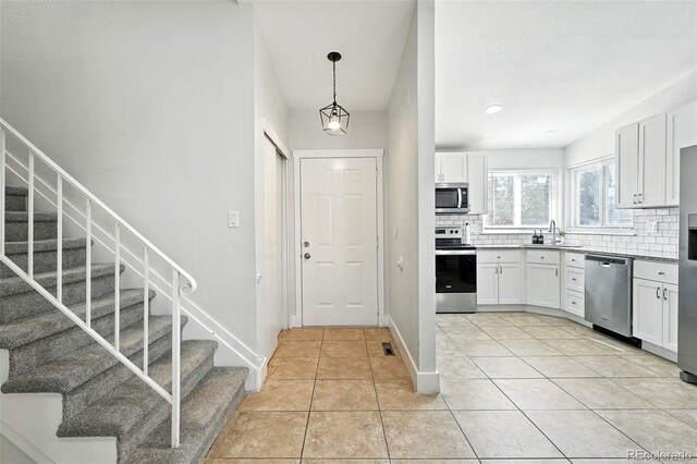 5317 S Truckee Ct, Centennial, CO 80015 - kitchen with stainless steel appliances, backsplash, light tile patterned floors, white cabinetry, and recessed lighting