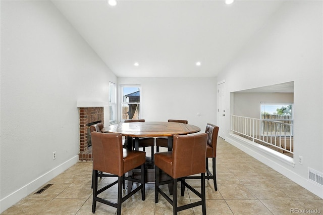 5317 S Truckee Ct, Centennial, CO 80015 - dining area with lofted ceiling, healthy amount of natural light, recessed lighting, light tile patterned floors, and a brick fireplace
