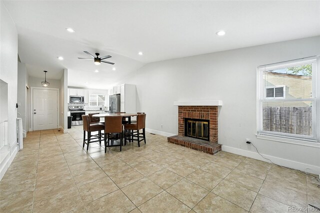 5317 S Truckee Ct, Centennial, CO 80015 - dining space featuring lofted ceiling, light tile patterned floors, ceiling fan, a brick fireplace, and recessed lighting
