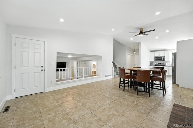 5317 S Truckee Ct, Centennial, CO 80015 - dining space with ceiling fan, stairway, light tile patterned floors, vaulted ceiling, and recessed lighting