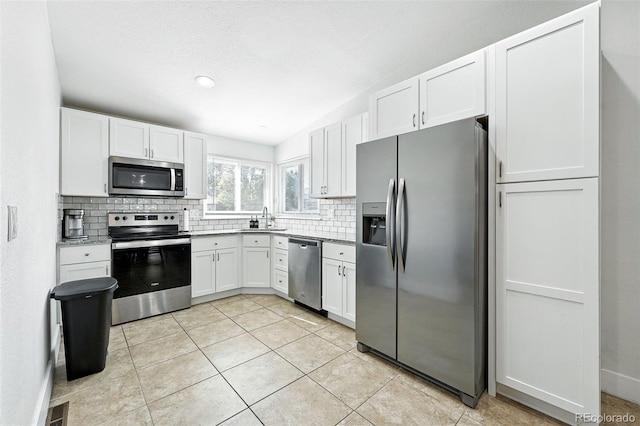 5317 S Truckee Ct, Centennial, CO 80015 - kitchen featuring stainless steel appliances, backsplash, white cabinetry, light tile patterned floors, and light countertops