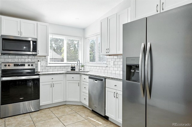 5317 S Truckee Ct, Centennial, CO 80015 - kitchen featuring stainless steel appliances, white cabinets, decorative backsplash, light tile patterned floors, and light stone countertops