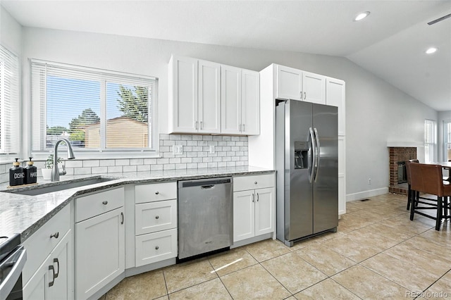 5317 S Truckee Ct, Centennial, CO 80015 - kitchen featuring stainless steel appliances, lofted ceiling, white cabinets, light tile patterned floors, and light stone countertops