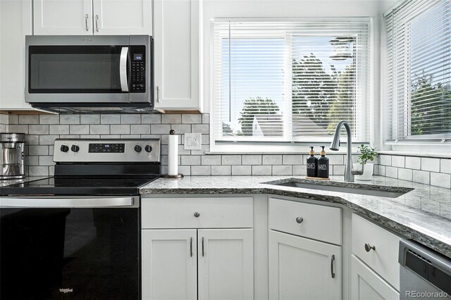 5317 S Truckee Ct, Centennial, CO 80015 - kitchen featuring appliances with stainless steel finishes, white cabinetry, backsplash, and plenty of natural light