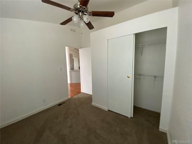 unfurnished bedroom featuring ceiling fan, a closet, and dark carpet